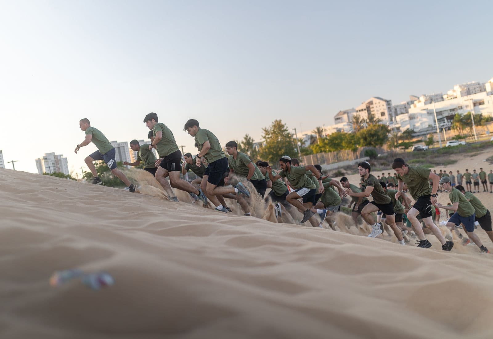 חניכי אדרנלין כושר קרבי רצים במעלה מדרון של חול